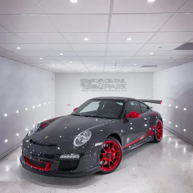 Porsche 911 GT3 RS gris con llantas rojas, en el estudio de Detail Park