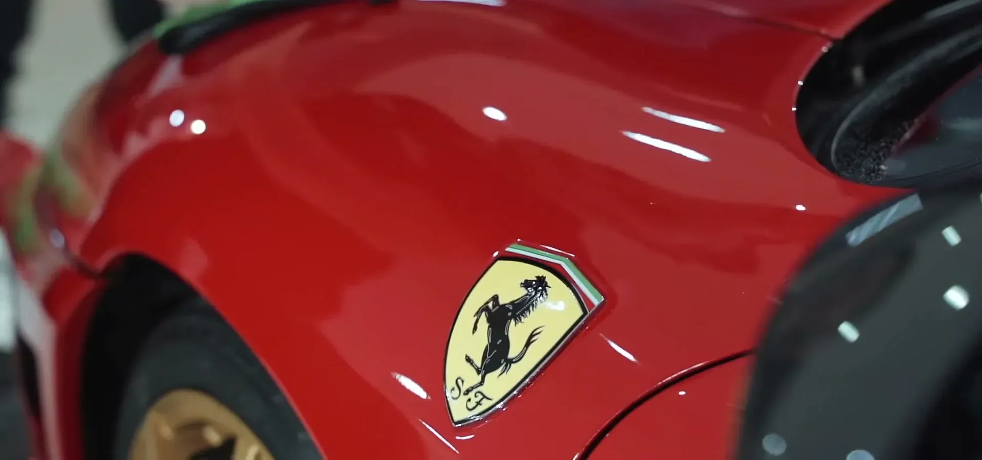 Aleta de un Ferrari F430 rojo recién corregido en Detail Park, con reflejos de espejo