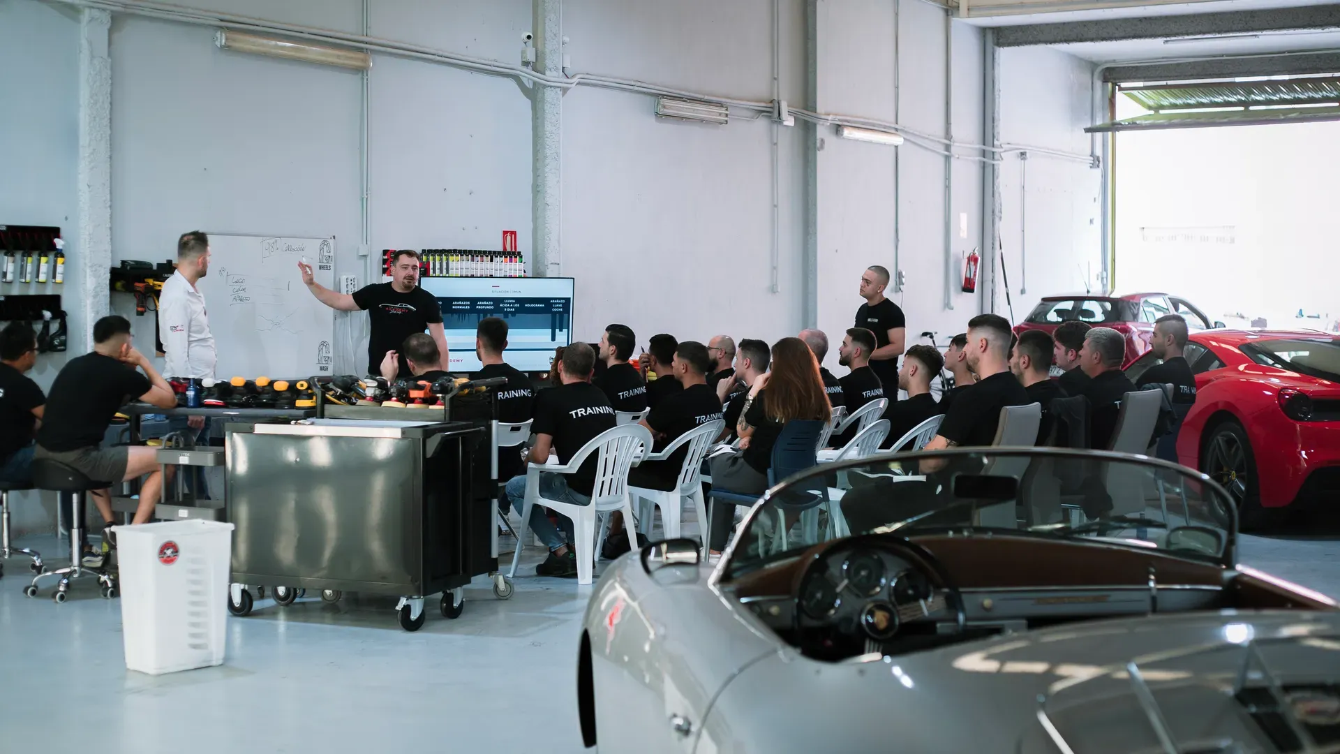 La nave de Detail Park en Alicante durante una formación, con un Porsche clásico y un Ferrari en primer plano