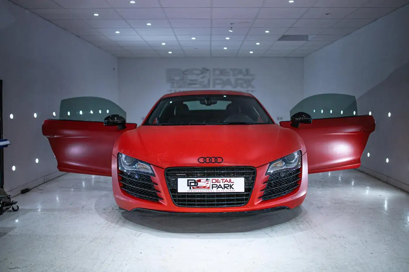 Audi R8 rojo con las puertas abiertas en el box de fotografía de Detail Park